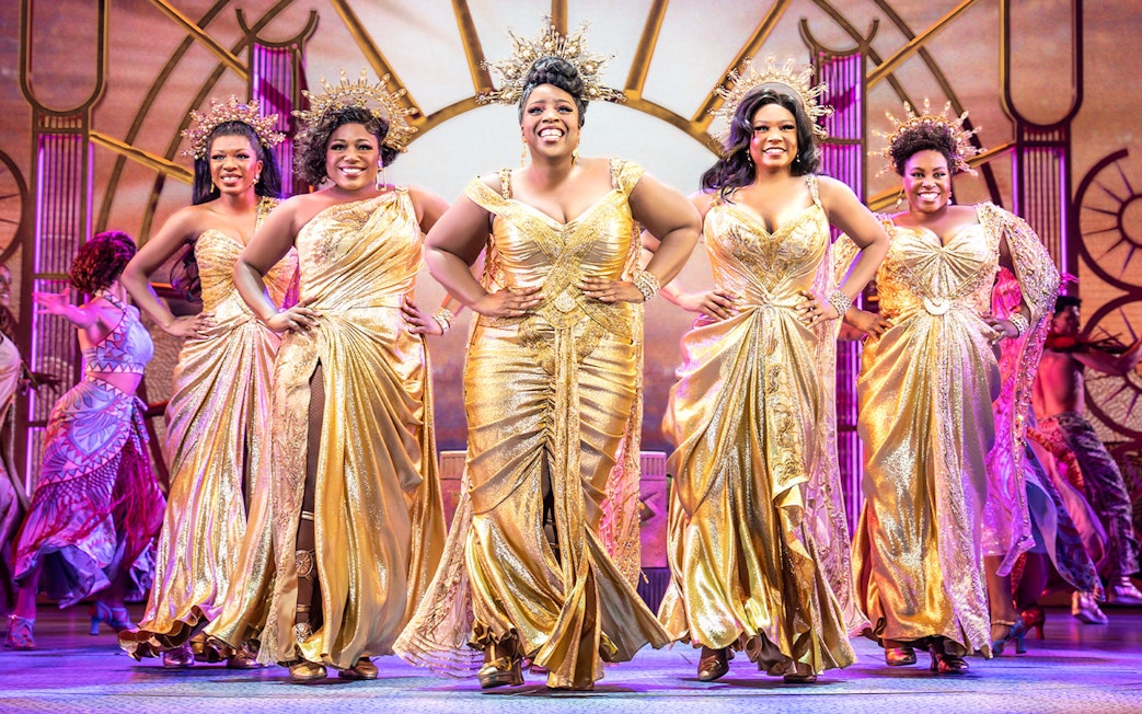 Performers in golden costumes on stage during Disney's Hercules musical.