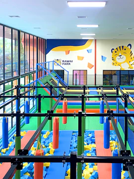 Indoor playground with obstacle course at Rawai Park, featuring colorful foam blocks and climbing structures.