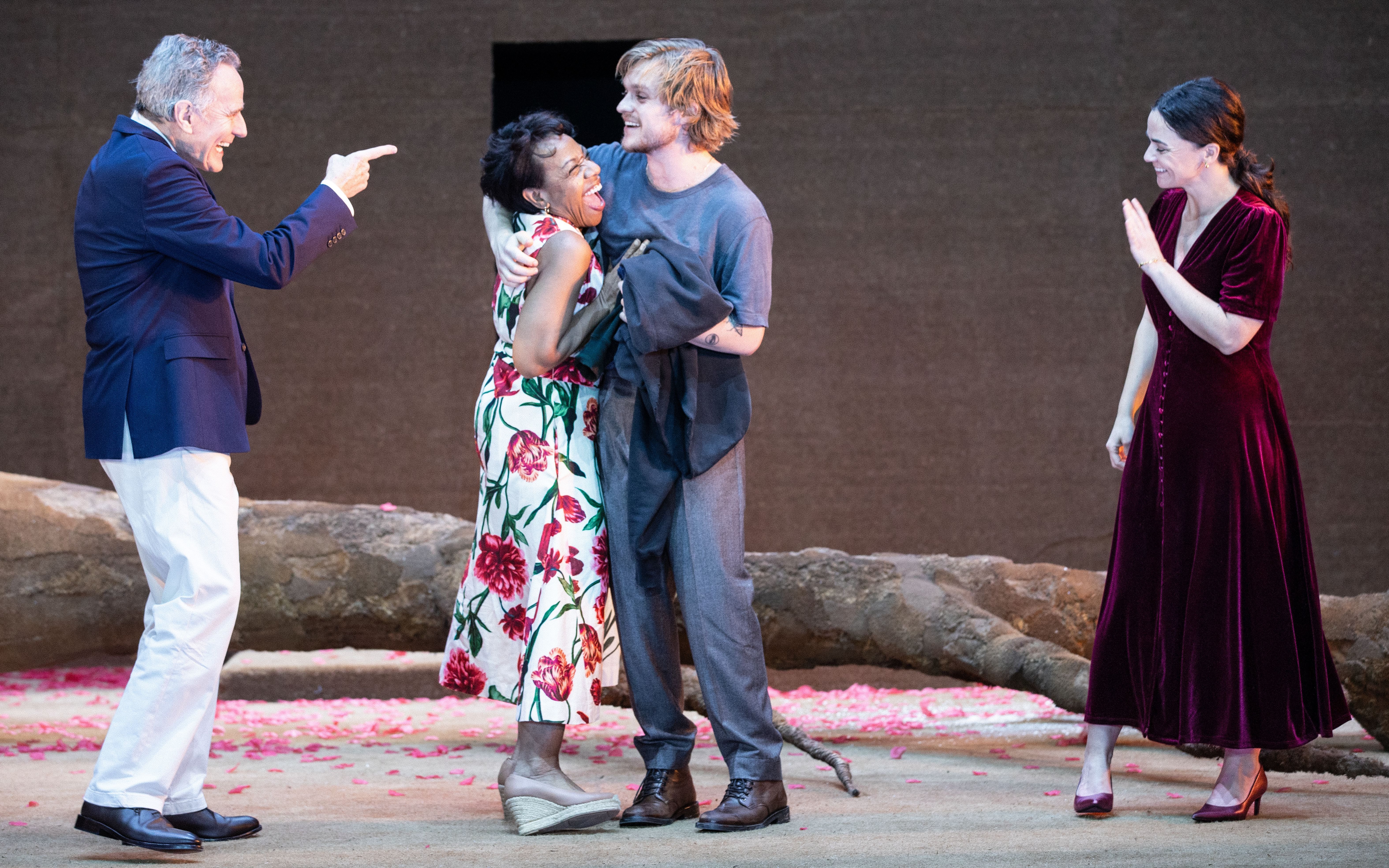 Actors performing on stage in the West End show "All My Sons" with a backdrop of fallen tree branches.