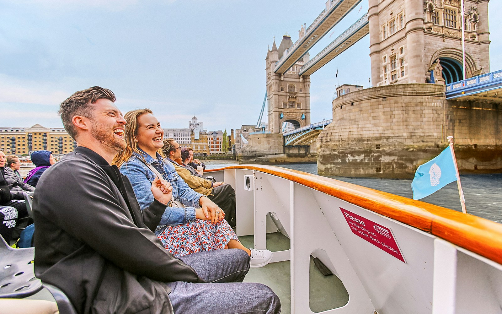 Tourists enjoying a river cruise near Tower Bridge, London.