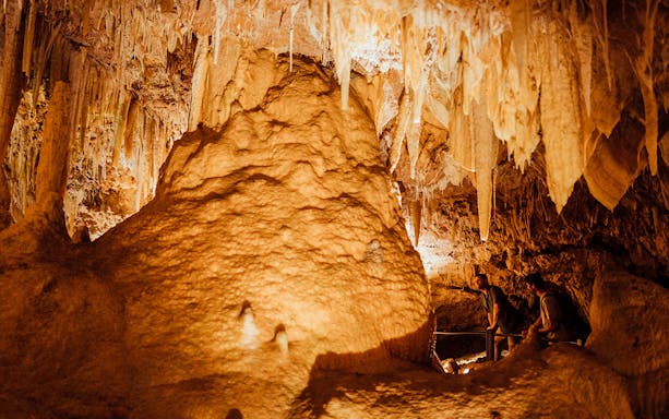 Ngilgi Cave stalactites and rock formations with visitors exploring the Ancient Lands Experience.