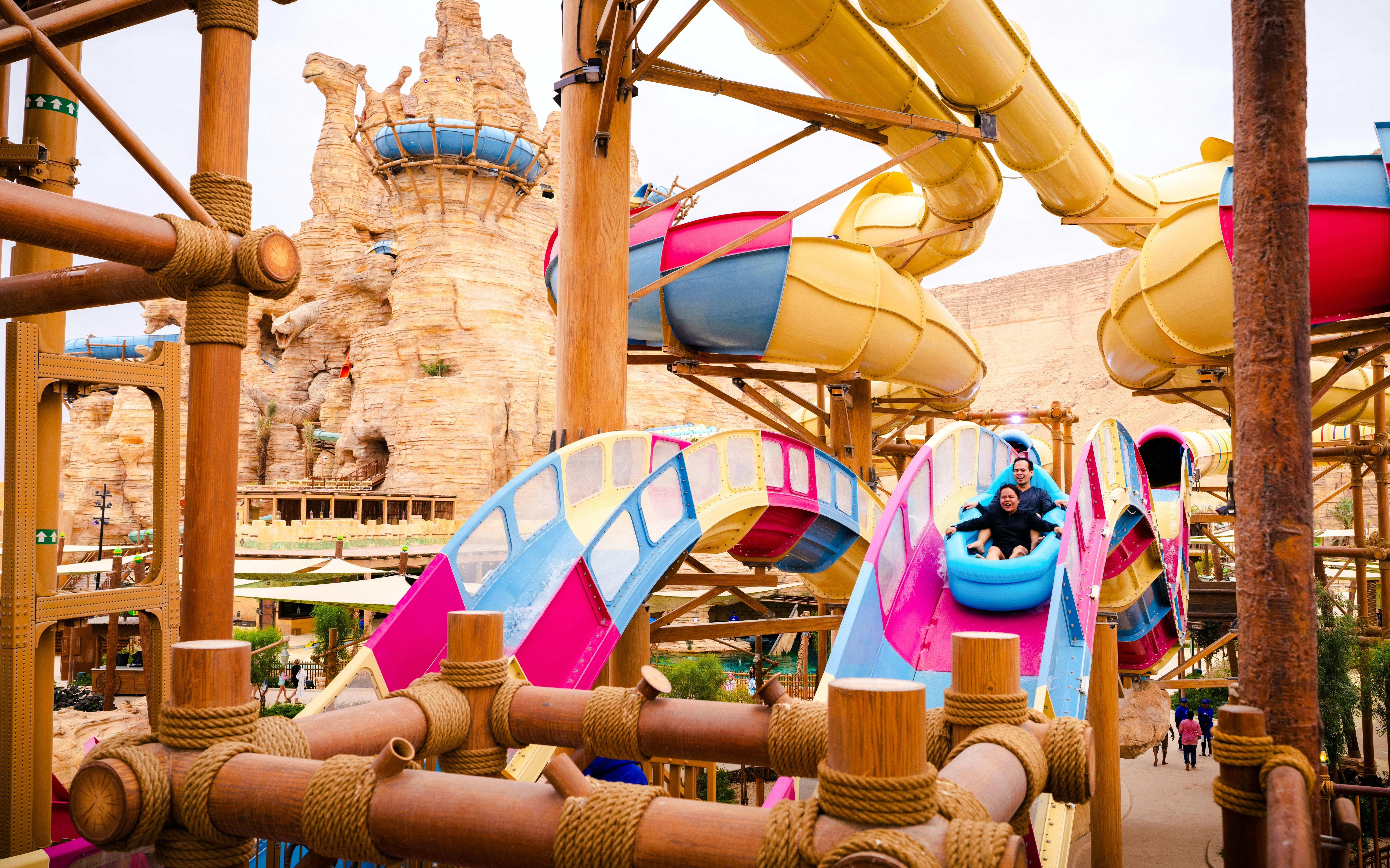 Visitors enjoying a colorful water slide at Aquarabia Water Theme Park, Qiddiya City, Saudi Arabia.