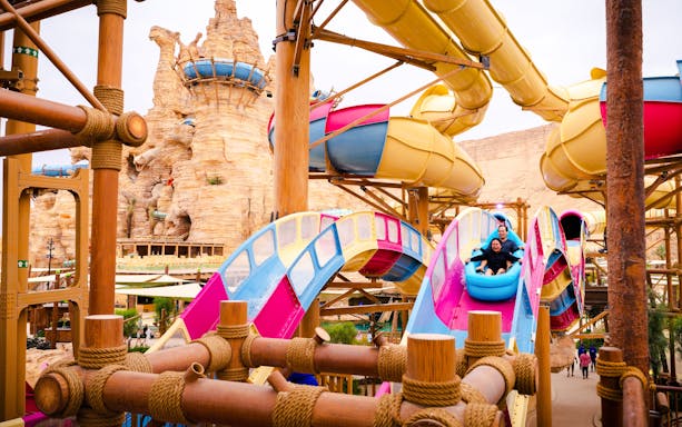 Visitors enjoying a colorful water slide at Aquarabia Water Theme Park, Qiddiya City, Saudi Arabia.