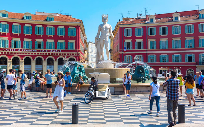 Fountain at Place Masséna in Nice with tourists, part of Monaco and Nice tour from Milan.