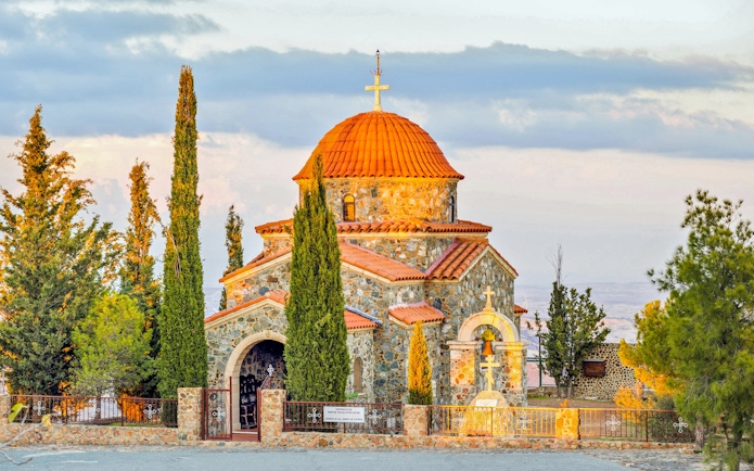 Church of All Saints with stone facade and red dome near Stavrovouni Monastery, Larnaka District, Cyprus.
