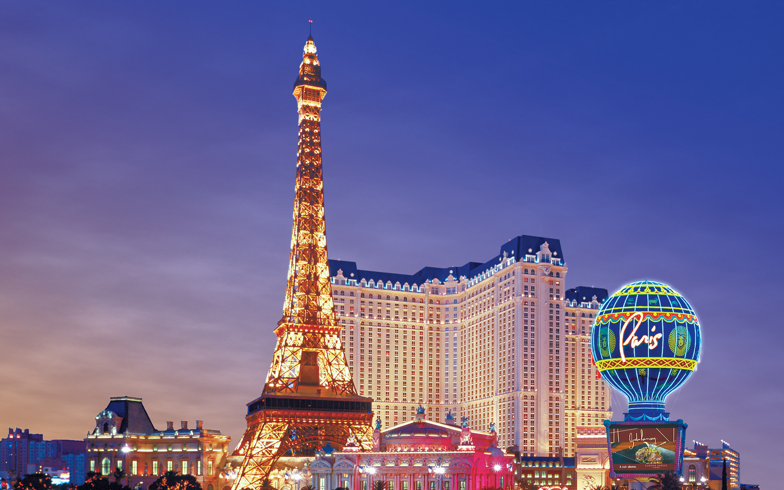 Eiffel Tower replica and Paris Hotel on Las Vegas Boulevard at dusk.