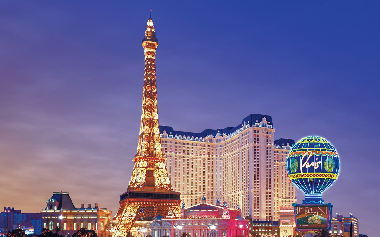 Eiffel Tower replica and Paris Hotel on Las Vegas Boulevard at dusk.