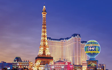 Eiffel Tower replica and Paris Hotel on Las Vegas Boulevard at dusk.