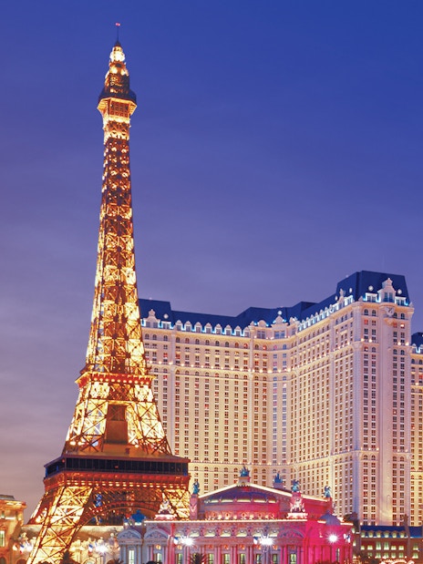 Eiffel Tower replica and Paris Hotel on Las Vegas Boulevard at dusk.