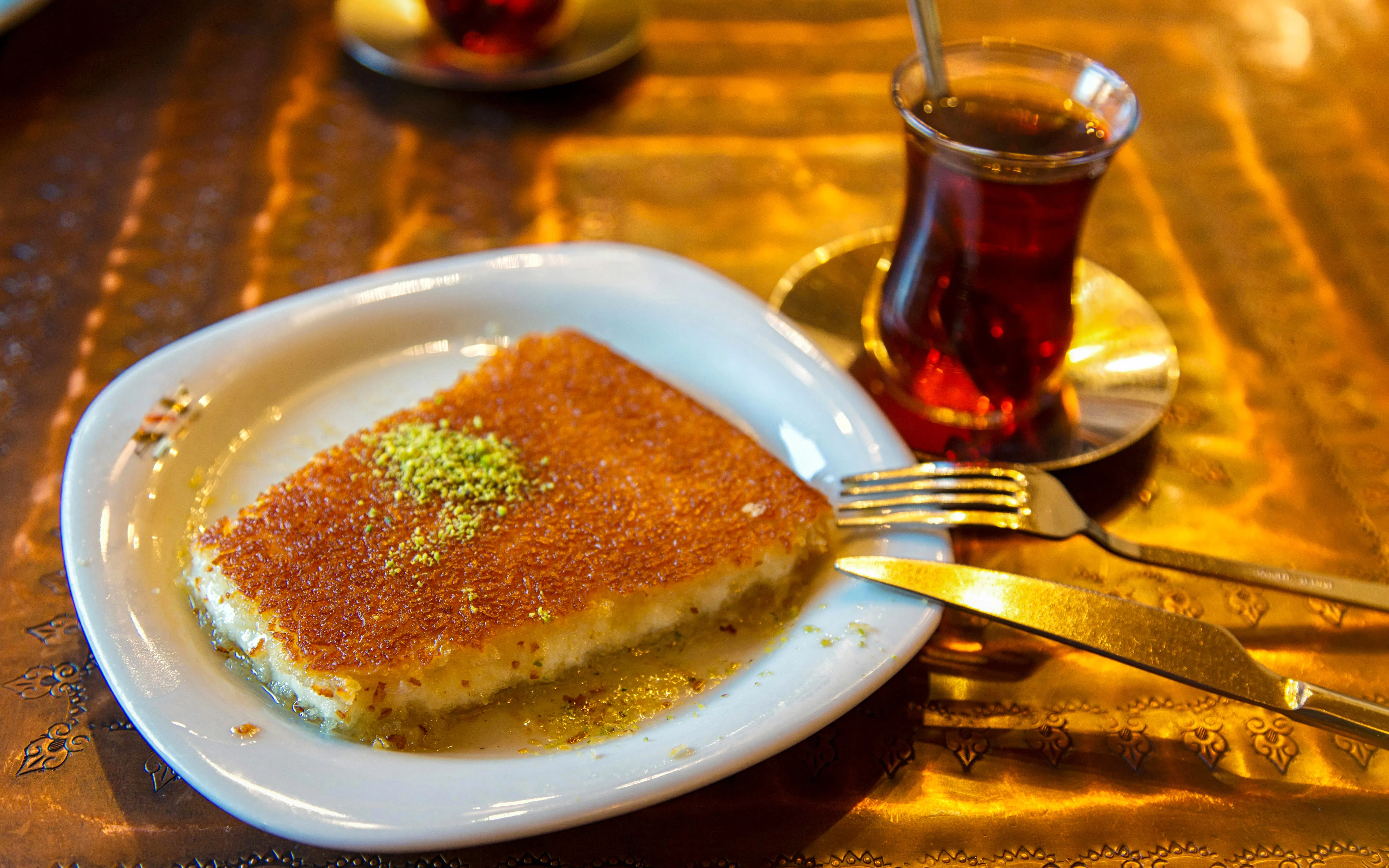 Kunefe with pistachio powder and tea on Istanbul street food tour.