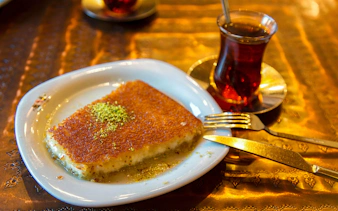 Kunefe with pistachio powder and tea on Istanbul street food tour.