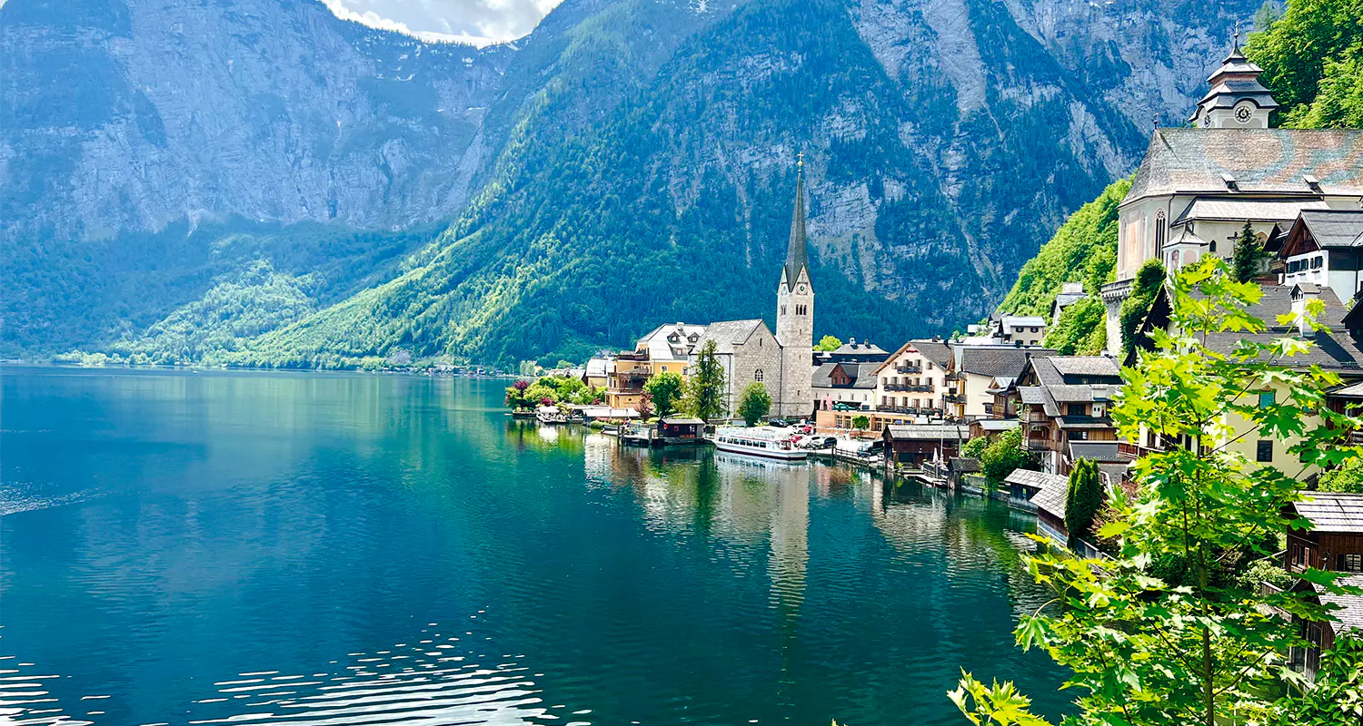 Hallstatt village by the lake with church and mountains, part of Vienna day trip tour.
