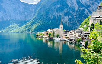Hallstatt village by the lake with church and mountains, part of Vienna day trip tour.