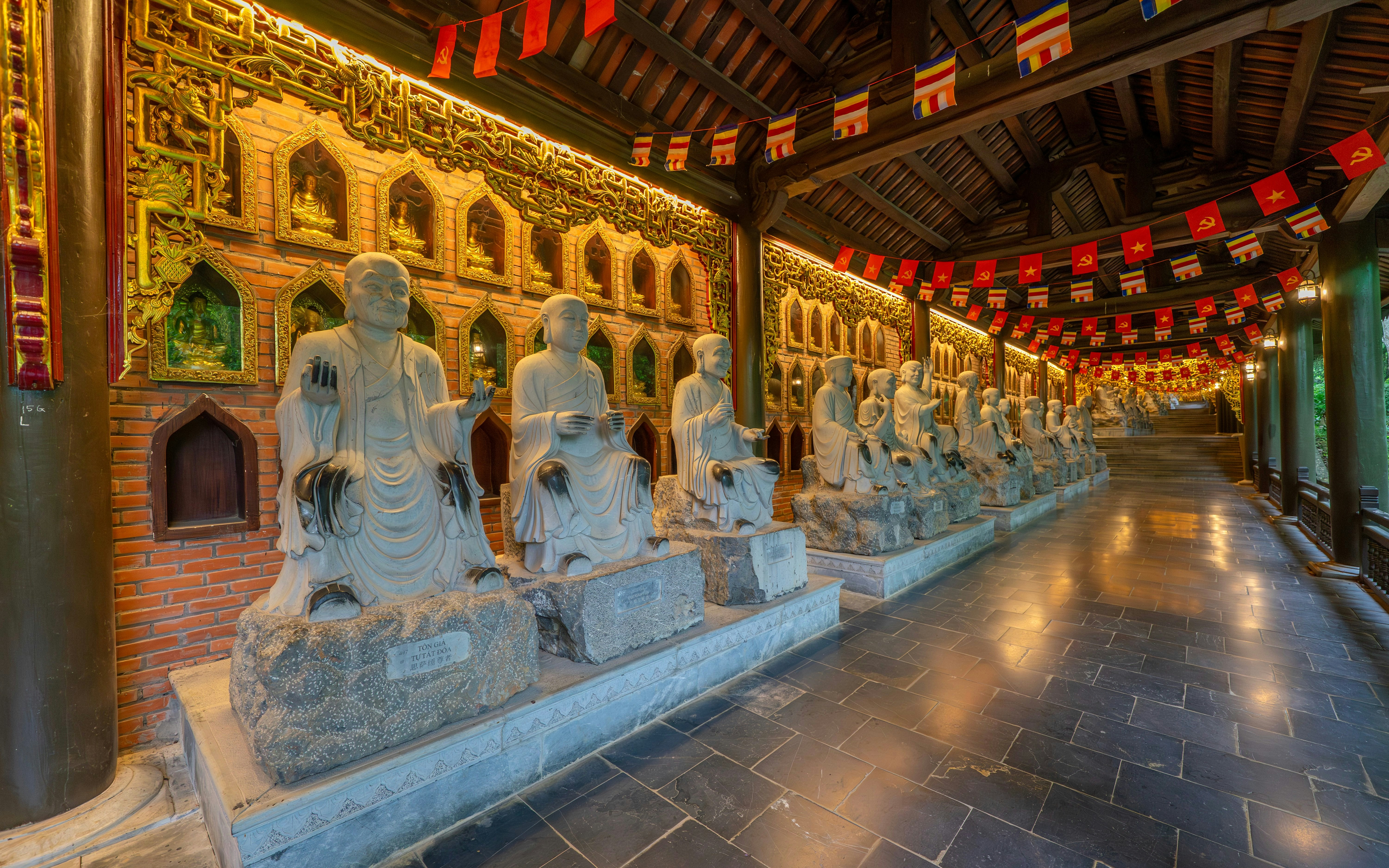 Buddha statues line a corridor leading to Bai Dinh Pagoda, Vietnam.