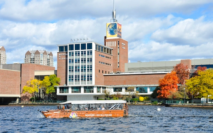 Boston Duck Tours boat cruising past the Museum of Science on the Charles River.