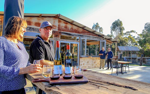 People enjoying wine at a rustic winery in False Cape, Kangaroo Island.