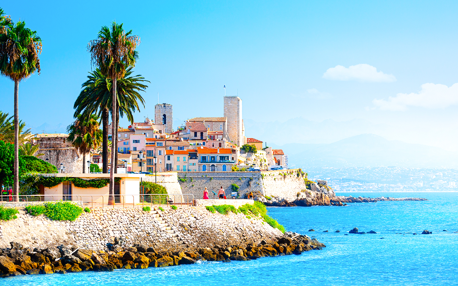 Coastal view of Antibes with historic buildings and palm trees, Provence, Cote d'Azur.