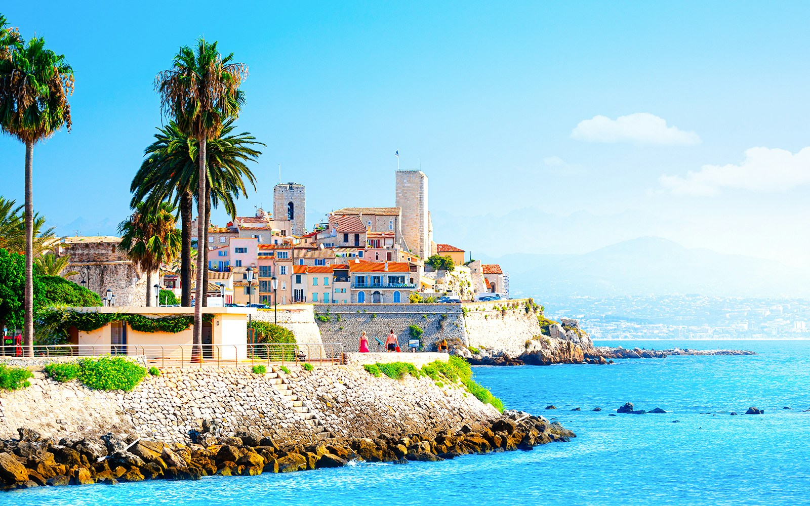 Coastal view of Antibes with historic buildings and palm trees, Provence, Cote d'Azur.