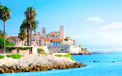 Coastal view of Antibes with historic buildings and palm trees, Provence, Cote d'Azur.