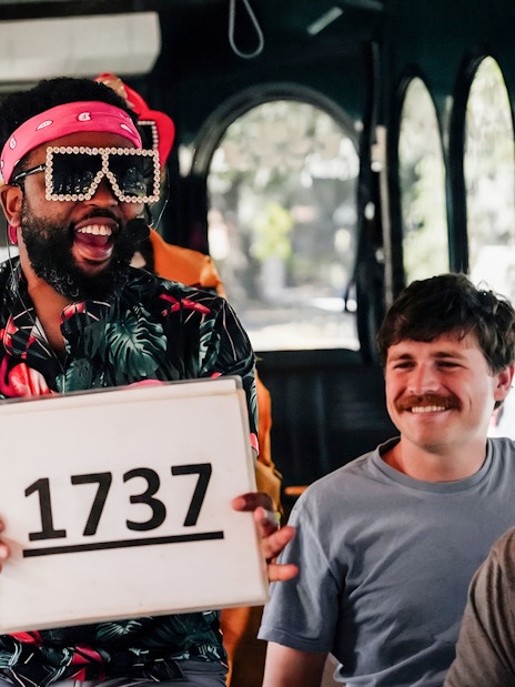 Tour guide holding a sign with "1737" on the Nashville For Morons Comedy Trolley Tour.