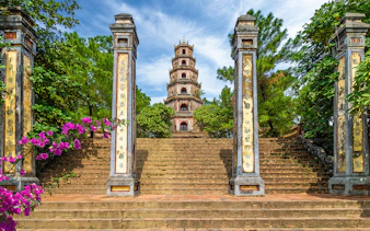 Thien Mu Pagoda entrance with stone pillars and steps in Hue, Vietnam.