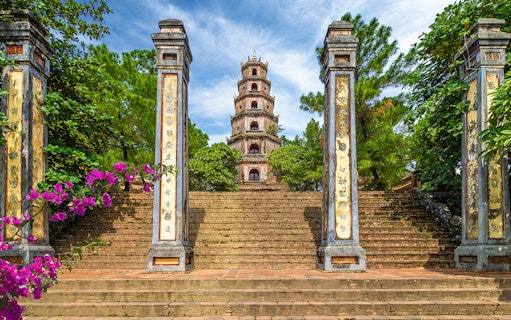 Thien Mu Pagoda entrance with stone pillars and steps in Hue, Vietnam.