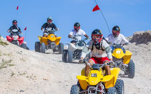 ATV riders navigating sand dunes on a Las Vegas guided off-road tour.