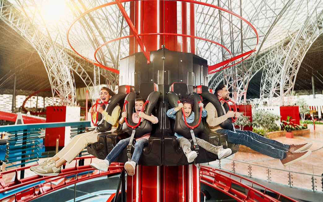People enjoying a thrilling ride at an indoor amusement park on the Corniche.