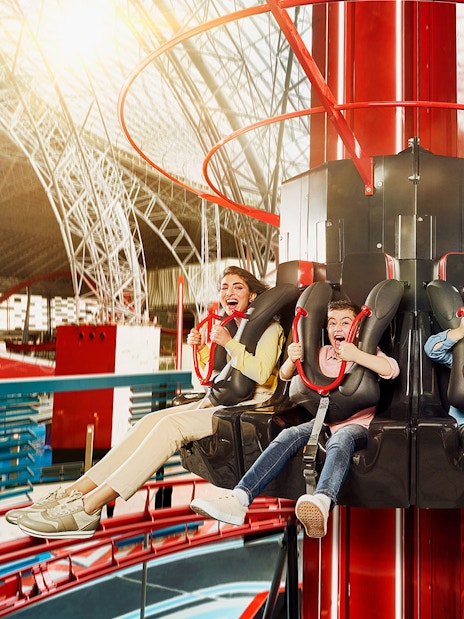 People enjoying a thrilling ride at an indoor amusement park on the Corniche.