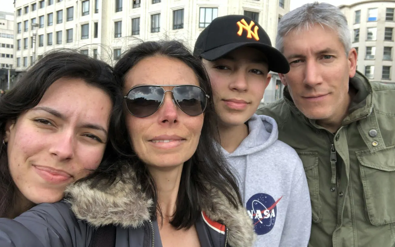 Family posing in front of historical buildings in Brussels during a self-guided city exploration game.