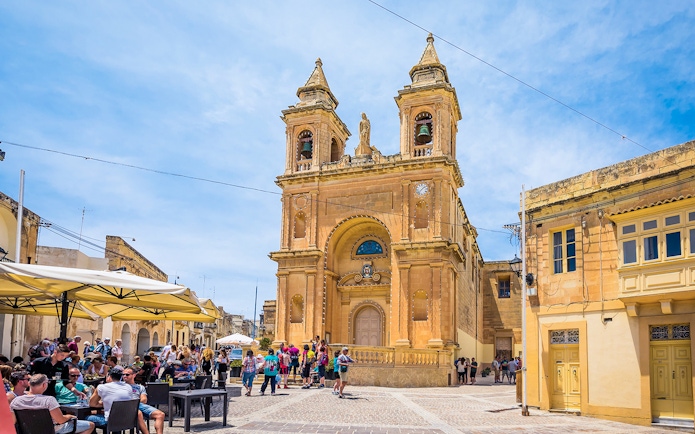Church facade with tourists in a Maltese square, part of the Prehistoric Temples & Highlights of the South tour.