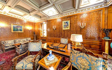Ceausescu Mansion interior with ornate wood paneling, vintage furniture, and decorative art.