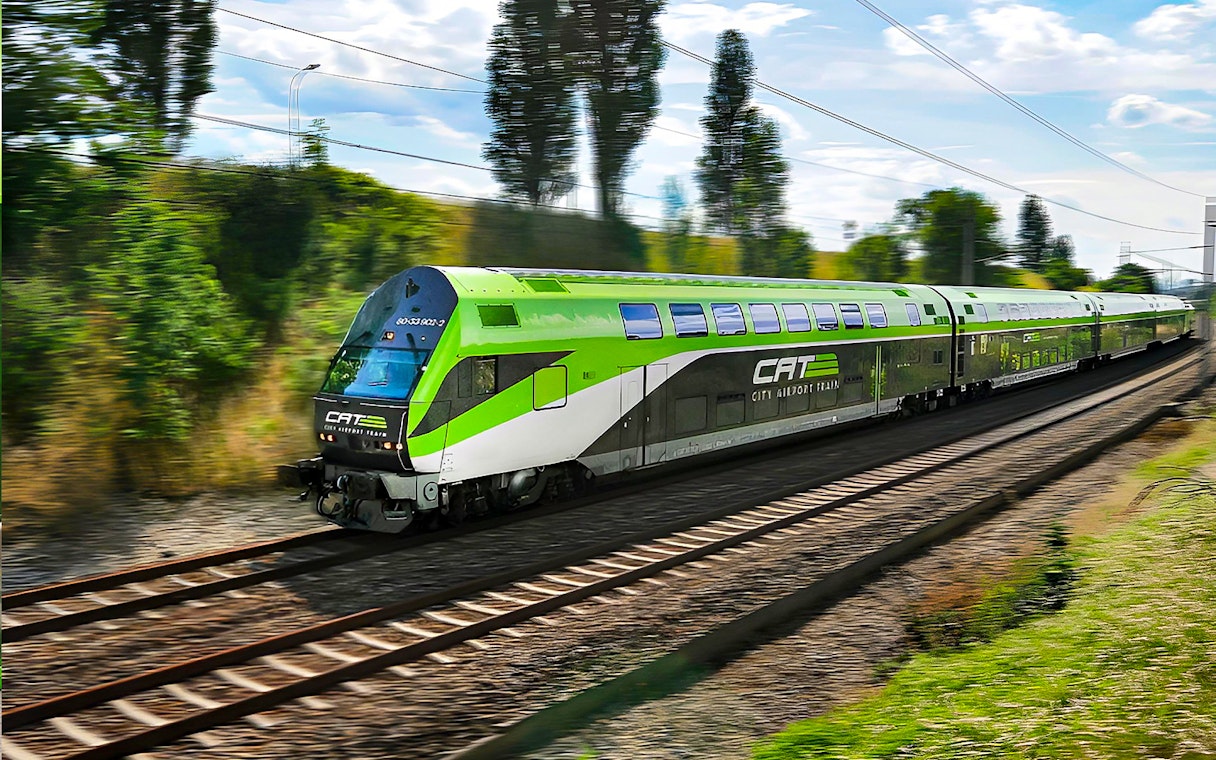 Vienna City Airport transfer train traveling on tracks through greenery.