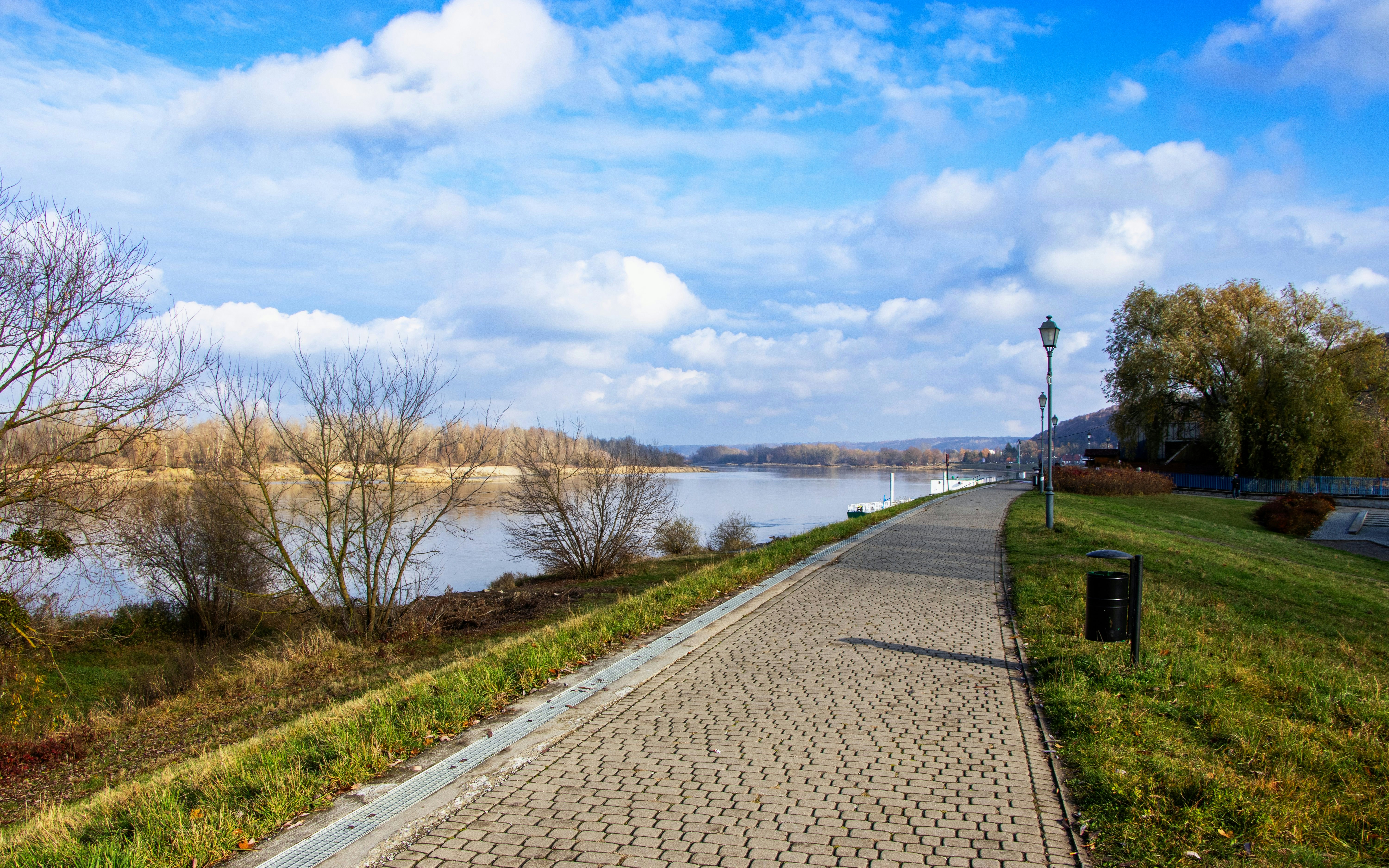 Scenic riverside pathway along the Vistula River in Kazimierz Dolny, Poland.