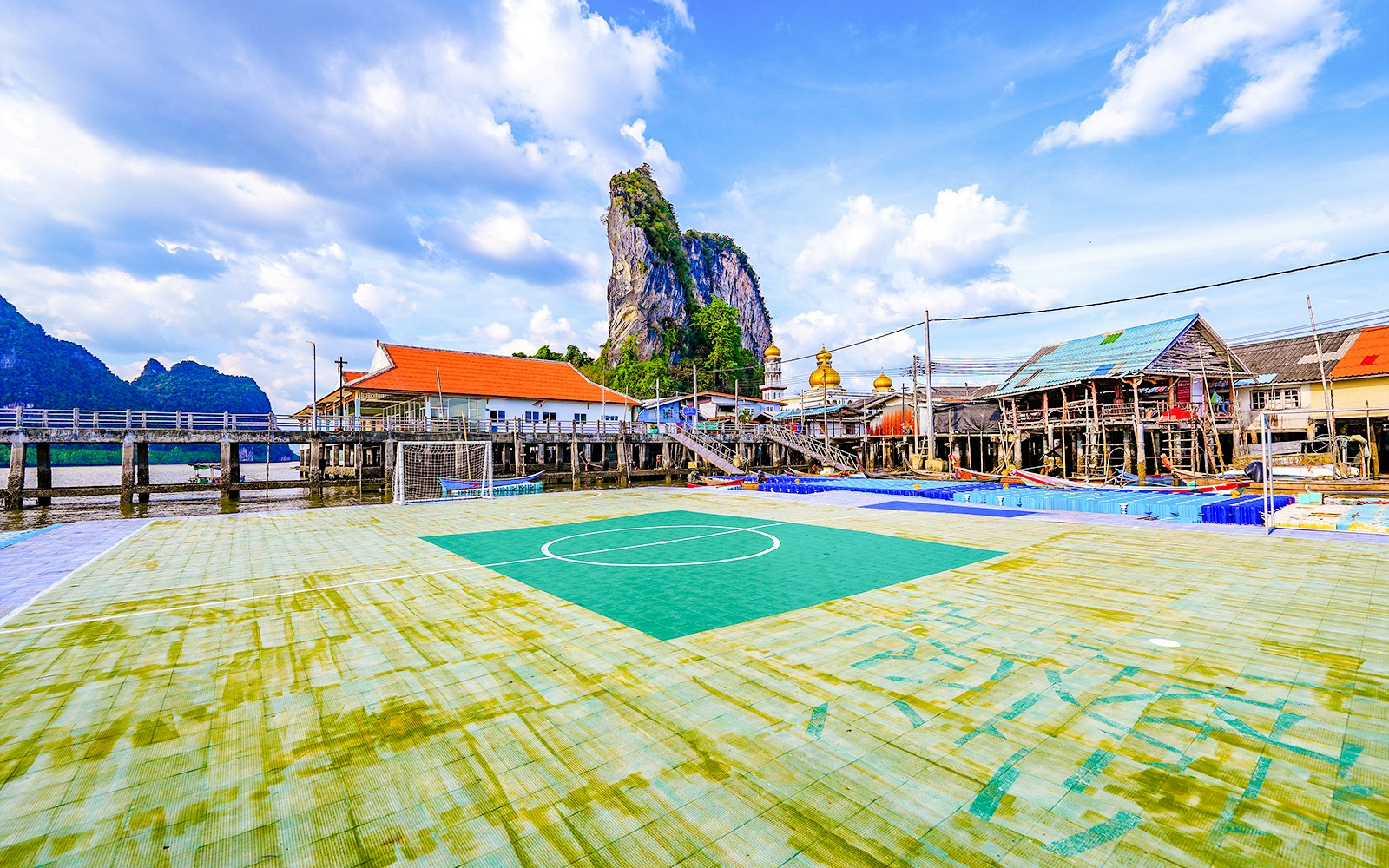 Floating soccer field in Koh Panyee fishing village with limestone cliff backdrop.