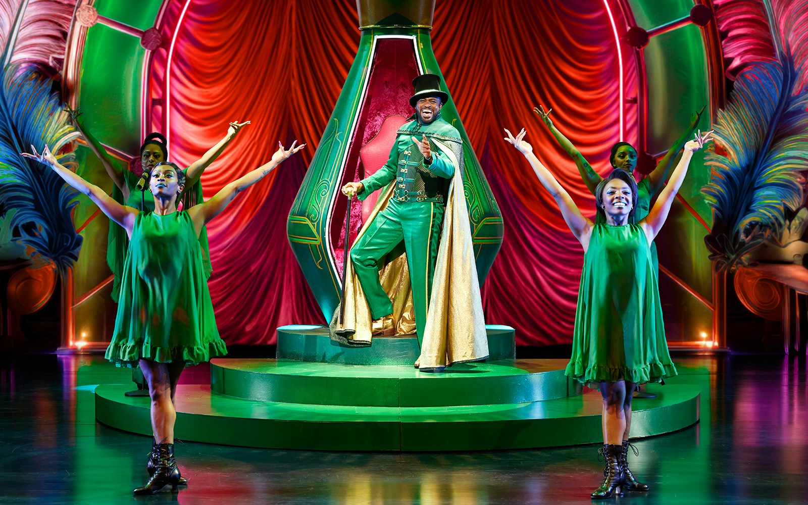 Performers in vibrant costumes on stage during a scene from The Wiz musical.