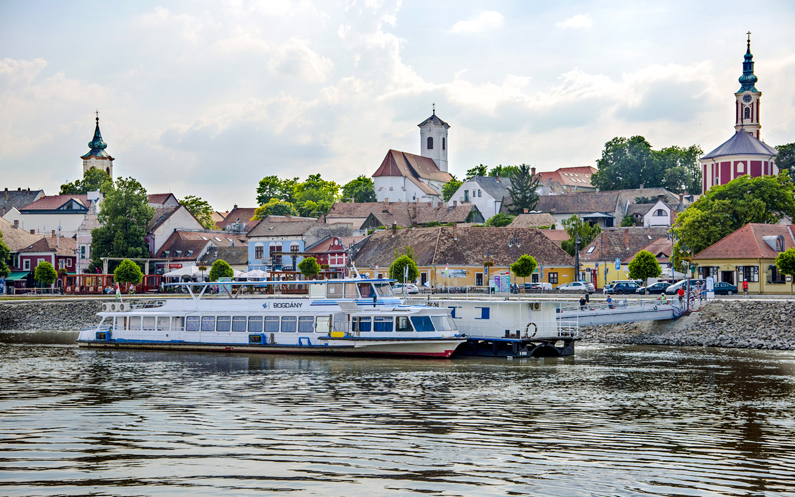 Boat docked with view of Szentendre's historic buildings and church spires.