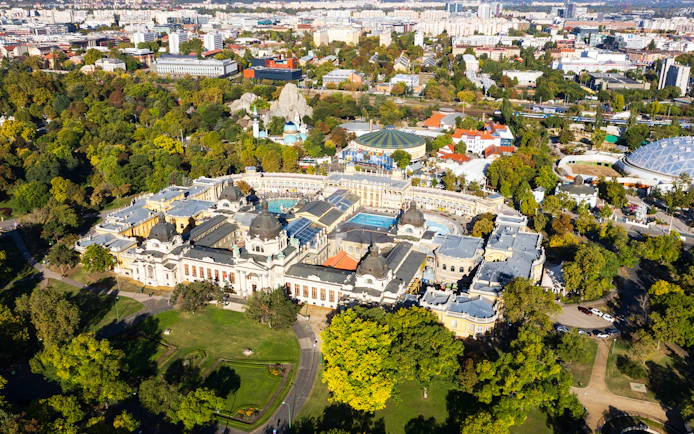 Aerial view of Szechenyi Baths surrounded by greenery in Budapest, Hungary.