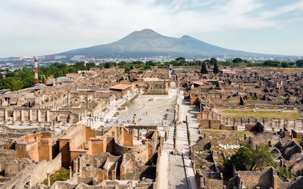Pompeii ruins with Mount Vesuvius in the background, part of Naples City Pass tour.