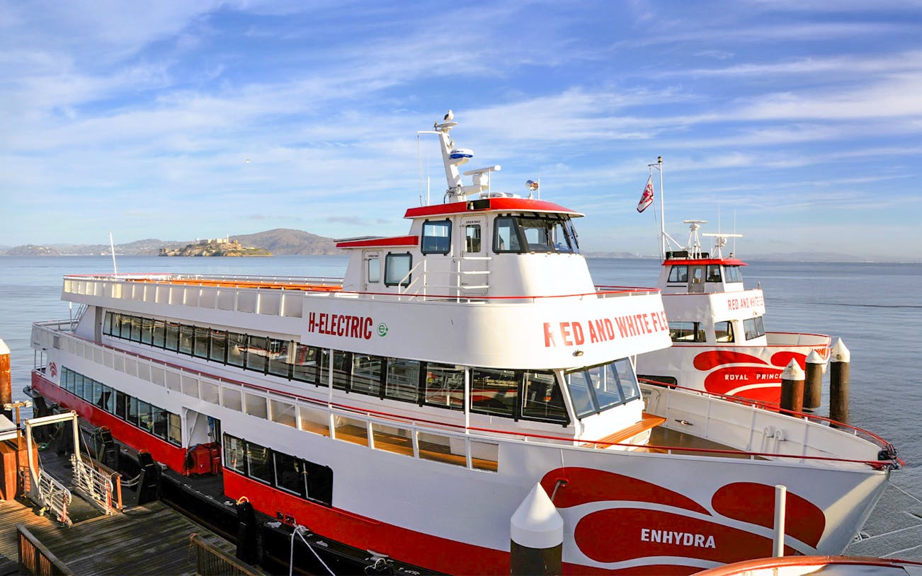 Golden Gate Bay cruise ship docked at San Francisco pier with city skyline in background.