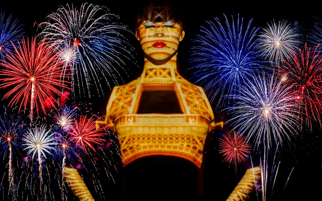 Fireworks over Paris with Eiffel Tower projection during Bastille Day dinner cruise.