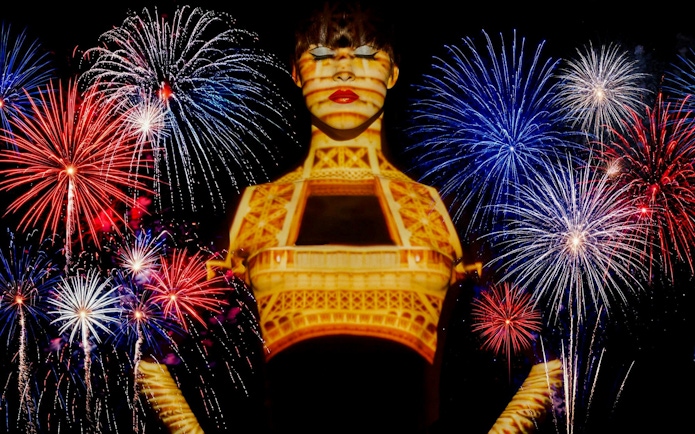 Fireworks over Paris with Eiffel Tower projection during Bastille Day dinner cruise.