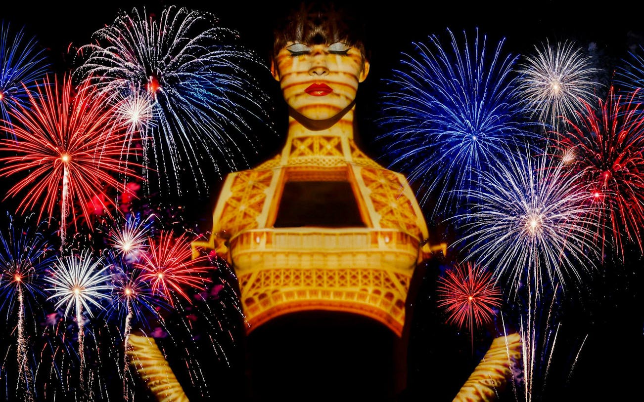 Fireworks over Paris with Eiffel Tower projection during Bastille Day dinner cruise.