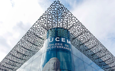 Mucem Marseille exterior with intricate lattice design and Mediterranean gallery sign.