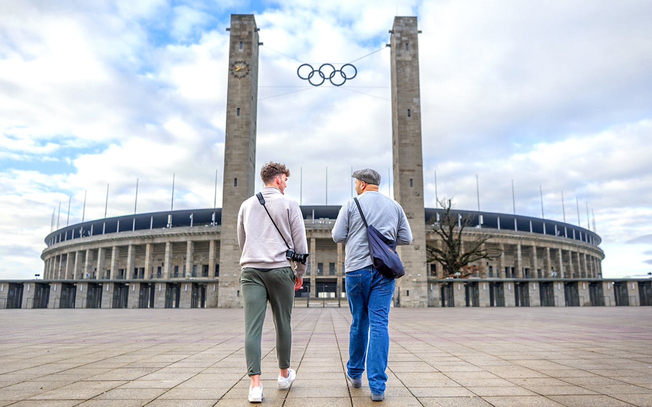 Visitors entering Olympiastadion Berlin through the main entrance, showcasing the iconic architecture.