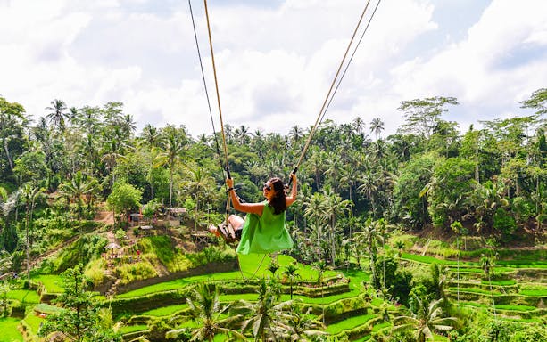 Swinging over rice terraces in Ubud, Bali, Indonesia.