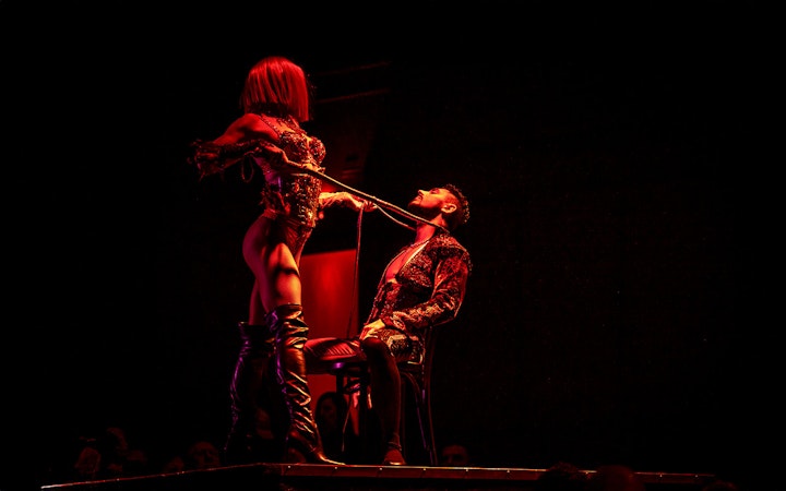 Performer in a dramatic pose during a Rouge show.