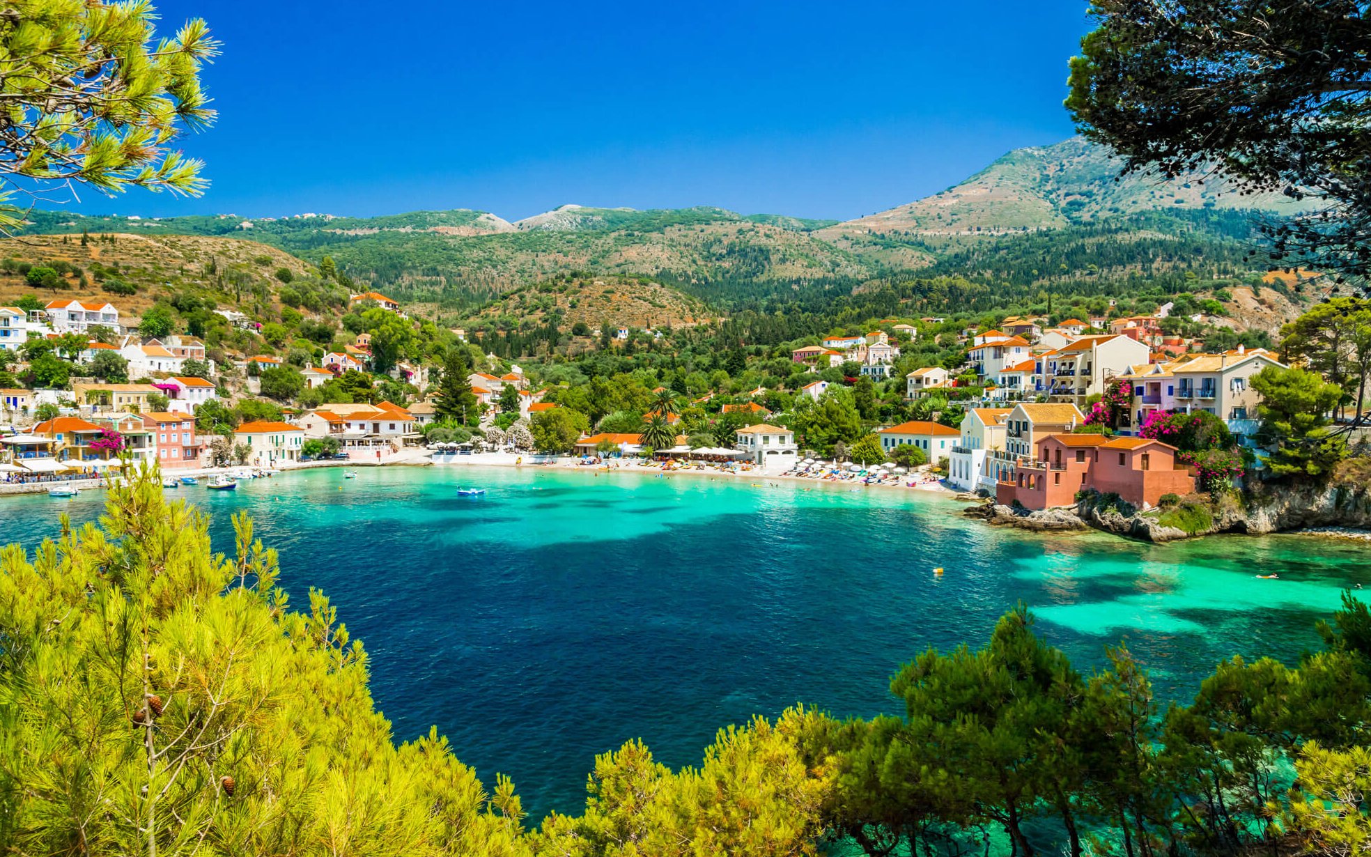 Assos Village coastline with colorful houses and clear blue water, Kefalonia island, Greece.