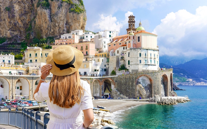 Young girl admiring Amalfi Coast view with colorful cliffside buildings.