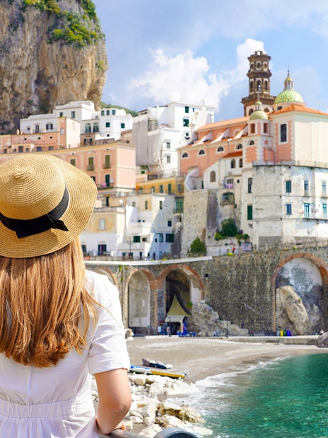 Young girl admiring Amalfi Coast view with colorful cliffside buildings.